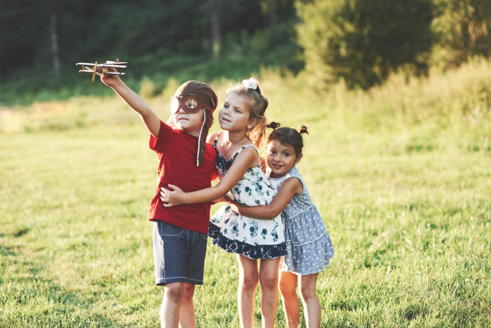 Watch the plane. Happy kids have good time beeng in a such wonderful place at summer.